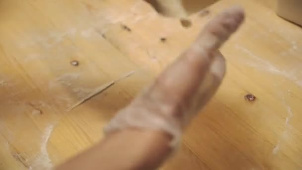 有人在木制桌子上做面团厨师正在餐厅厨房里把面团铺开 手弄皱面团 食物录像关闭厨房 — 图库视频影像