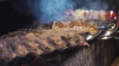 Birisi kebap pişiriyor. Şef bir et kebabı hazırlıyor. Şiş kebap kazıkta hazırlanıyor. Et kızardı. Yemek videosu yavaş çekim restoran mutfağını kapatıyor.. 