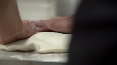 Şef pizza hamuru yapıyor. Eller ve hamur. Pizza hamuru pişiriyorum. Şef pizza için hamur hazırlıyor..