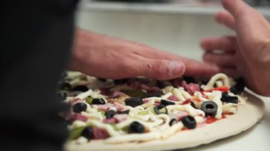 Şef İtalyan restoranında pizza pişiriyor. İtalyan pizzası yapma süreci. Birisi mutfakta etli pizza hazırlıyor.. 