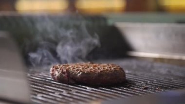 Burger pirzolası. Hamburger için pirzola pişirme işlemi. Şef restoranın mutfağında bir burger pişiriyor. Burger pirzolası kızarıyor.. 