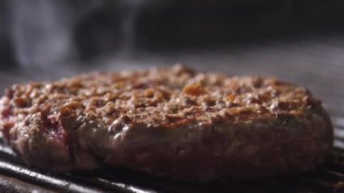 Burger pirzolası. Hamburger için pirzola pişirme işlemi. Şef restoranın mutfağında bir burger pişiriyor. Burger pirzolası kızarıyor.. 