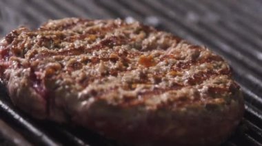 Burger pirzolası. Hamburger için pirzola pişirme işlemi. Şef restoranın mutfağında bir burger pişiriyor. Burger pirzolası kızarıyor.. 