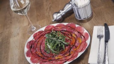 Rozetli ve balzamik soslu Carpaccio. Restorandaki güzel yemek. Restoranda güzel bir carpaccio servisi. Bir tabak carpaccio..