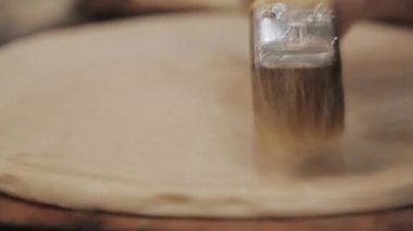 Birisi ahşap bir masada hamur yapıyor. Şef restoranın mutfağında hamur topluyor. Eller hamuru buruşturur. Yemek videosu mutfağı kapatın..