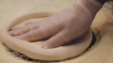 Birisi ahşap bir masada hamur yapıyor. Şef restoranın mutfağında hamur topluyor. Eller hamuru buruşturur. Yemek videosu mutfağı kapatın..