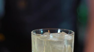 Birisi cam sürahide buzları karıştırıyor. Kokteyl hazırlıyorum. Barmen buzlu içeceği karıştırıyor..