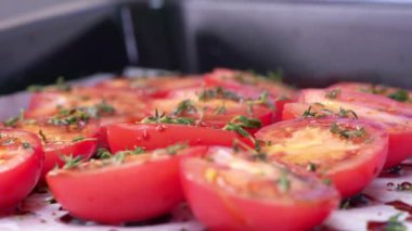 Domates pişirmek. Şef kekik ile domatesleri dekore ediyor. Kekik yavaş çekimde domateslerin üzerine düşüyor.