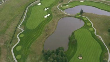 Golf sahası bir kuşun uçma yüksekliğinden. Hava golf sopası. İHA golf sahasında uçuyor. Yukarıdan golf sahasının manzarası.