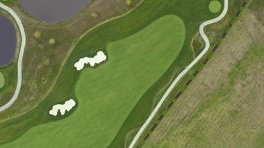 Golf sahası bir kuşun uçma yüksekliğinden. Hava golf sopası. İHA golf sahasında uçuyor. Yukarıdan golf sahasının manzarası.
