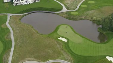 Hava golf sopası. Golf sahası bir kuşun uçma yüksekliğinden. İHA golf sahasında uçuyor. Yukarıdan golf sahasının manzarası.
