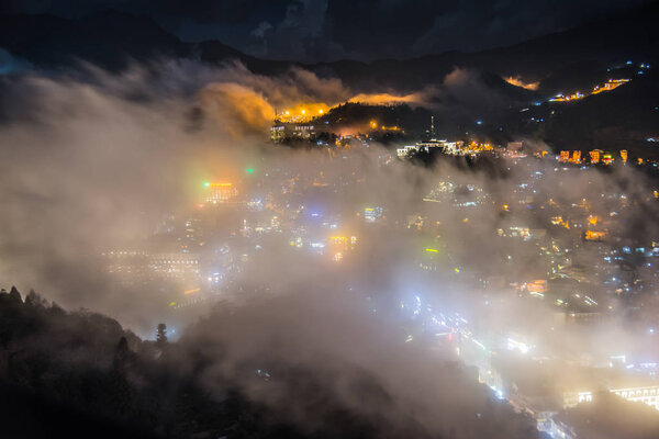 The fog moving pass Sapa village in Vietnam in evening time .