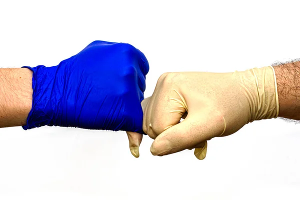 Hände in blau-weißen OP-Schutzhandschuhen begrüßen sich mit kleinen Fingern. — Stockfoto