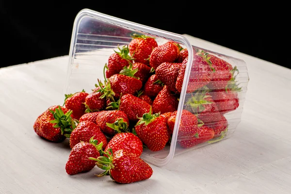 Overturned Transparent Plastic Container Red Ripe Juicy Strawberries Scattered Table — Stock Photo, Image