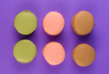 Mor arka plan üzerinde renkli macarons
