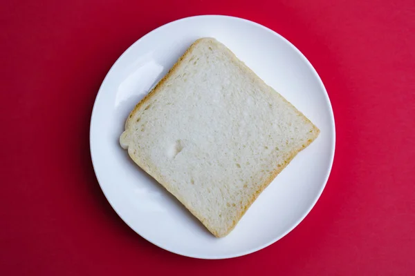Eine Scheibe Toast Auf Einem Weißen Teller Roter Hintergrund — Stockfoto