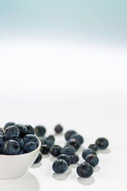 Yaban mersini bir beyaz kase, dikey ve uzay kopyalayın