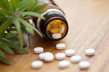 Tabletler ile homeopatik ilaç-ahşap masada tabletlerle şişe