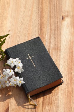 İncil ile ahşap bir masaya çiçek