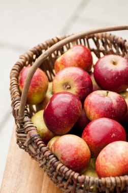 Pek çok kırmızı elma ile bir hasır sepet 