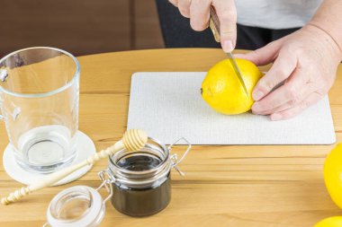 Kadın taze limon çayı hazırlamak için bir limon dilimleri