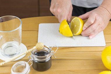 Kadın taze limon çayı hazırlamak için bir limon dilimleri