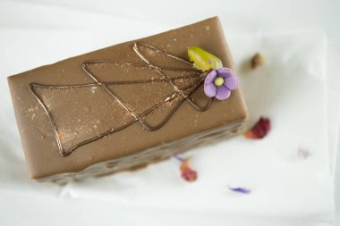 Bir parça süsler ve badem ezmesi çiçek ile çikolatalı kek