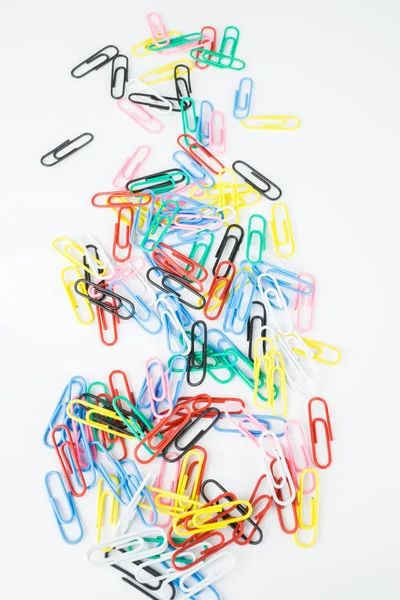 Colorful paper clips on white background, vertical