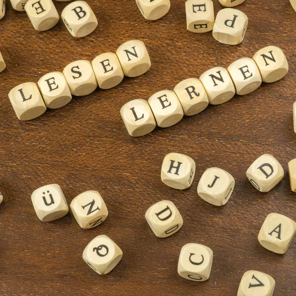 Many wooden cubes with the German words for learn to read