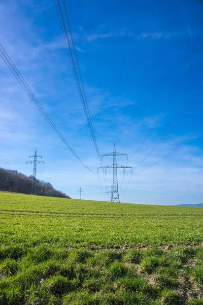 High voltage line in front of bright blue sky