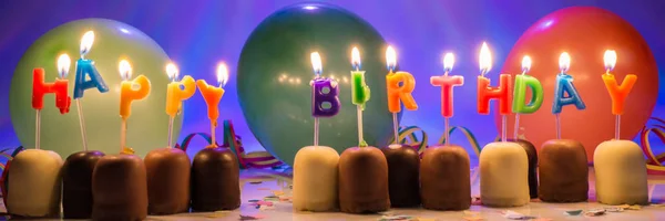 Velas Aniversário Coloridas Queimando Com Pequenos Doces Chocolate Balões Confetes — Fotografia de Stock