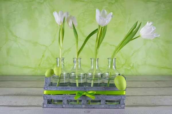 Easter, four tulips in bottles with green easter eggs