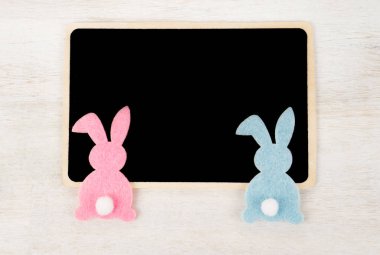İki renkli Paskalya tavşanları boş kara tahta ile
