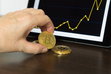 Grafik ile elinde tutan bitcoins tablet