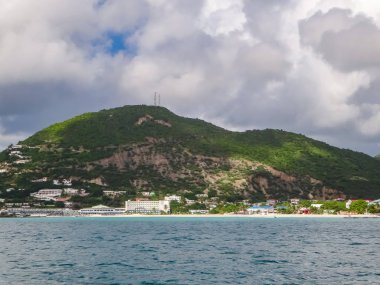 Dağlar ve mavi bulutlu gökyüzü ile Karayip Adası