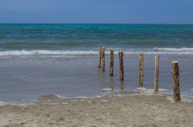 wooden pillars on the beach clipart