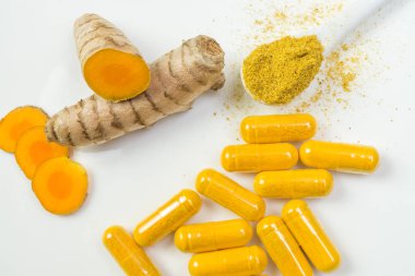 Zerdeçal kök ve curcuma kapsül ve bir kaşık curcuma toz