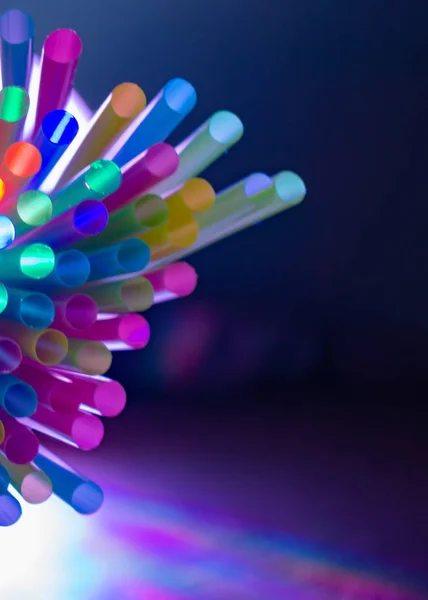 Colorful straws with party lights and blue spot light