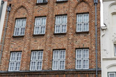 Çok penceresi olan eski bir tuğla ev cephe