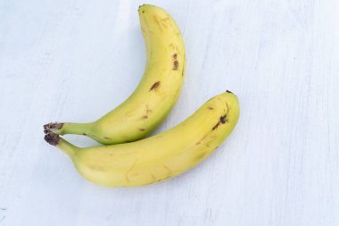 Beyaz ahşap zemin üzerinde iki muz