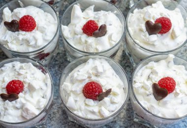 Gözlük çatlar, çikolata bir kalp ve bir ahududu ile taze kremalı tatlılar