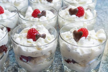 Gözlük çatlar, çikolata bir kalp ve bir ahududu ile taze kremalı tatlılar