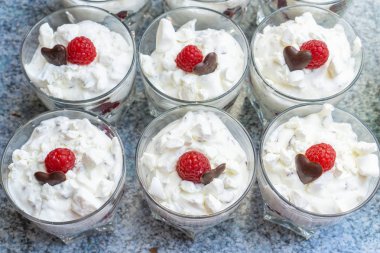 Gözlük çatlar, çikolata bir kalp ve bir ahududu ile taze kremalı tatlılar