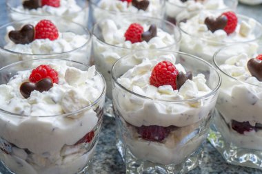 Gözlük çatlar, çikolata bir kalp ve bir ahududu ile taze kremalı tatlılar