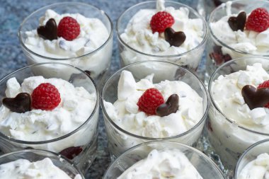 Gözlük çatlar, çikolata bir kalp ve bir ahududu ile taze kremalı tatlılar