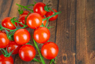 Bir salkım, ahşap arka plan ve kopya alanı birçok taze kokteyl domates