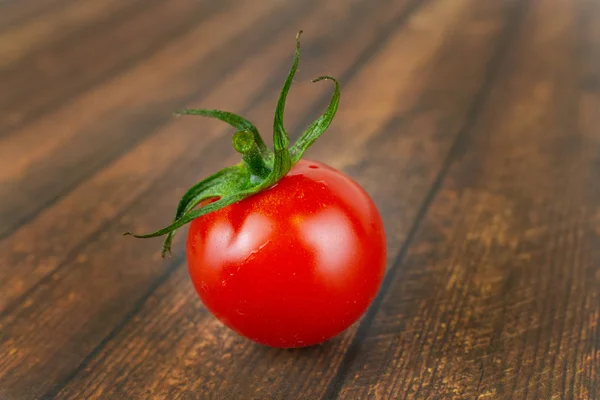 木制背景上的一个新鲜番茄 — 图库照片