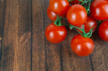 Bir salkım, ahşap arka plan ve kopya alanı birçok taze kokteyl domates