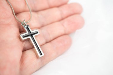 Elinde siyah giriş tutan gümüş bir haç