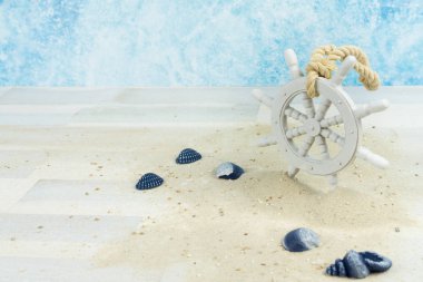 Kumlu, kabuklu ve eski beyaz ahşap tekerli bir deniz arka planı.
